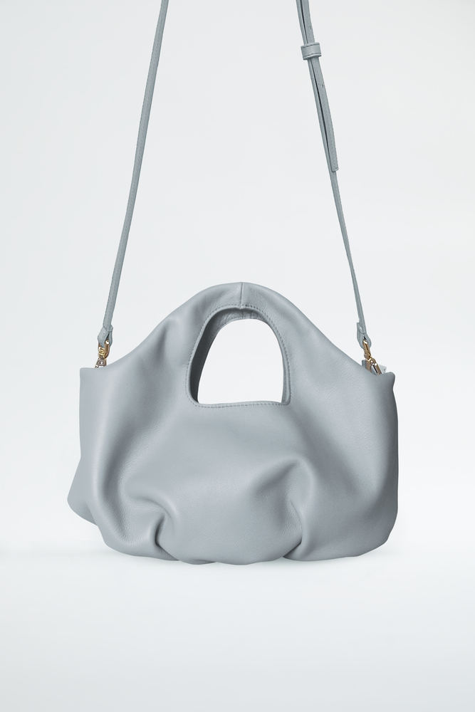 
                  
                    Pillow handbags with pleats in the base. Grey dolphin color and removable long strap. Soft draped bag by Blame Lilac 
                  
                