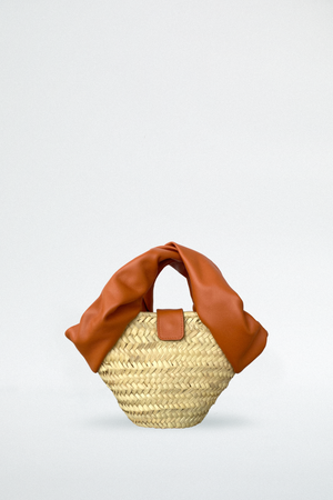 
                  
                    Blame Lilac raffia tote bag made by hand. Small mini size with a supple and knotted handle. summer season at the beach. Dark orange tan color
                  
                